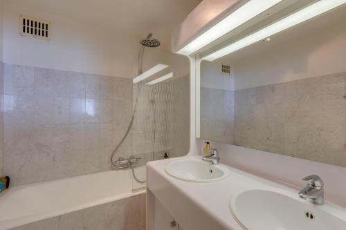 a bathroom with a sink and a tub and a mirror at Luxury Suite with Seaview in Ostend