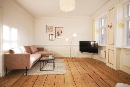 a living room with a couch and a tv at New Harbor - Carolinas Apartment in Copenhagen
