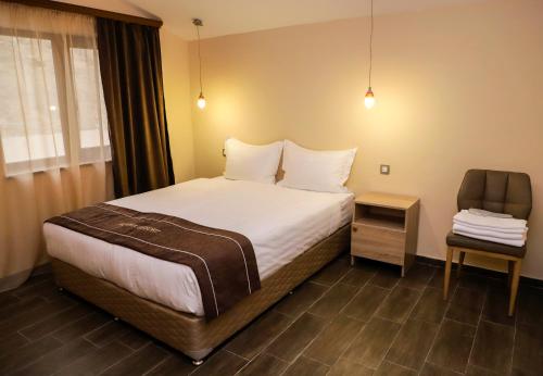 a hotel room with a bed and a chair at Alaska Resort in Tsaghkadzor