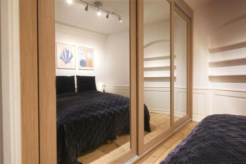 a bedroom with a bed and a large mirror at New Harbor - Carolinas Apartment in Copenhagen