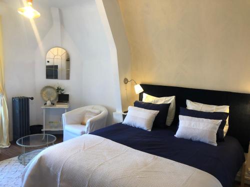een slaapkamer met een groot bed en een stoel bij Maison de la Comtesse in Cosne-dʼAllier