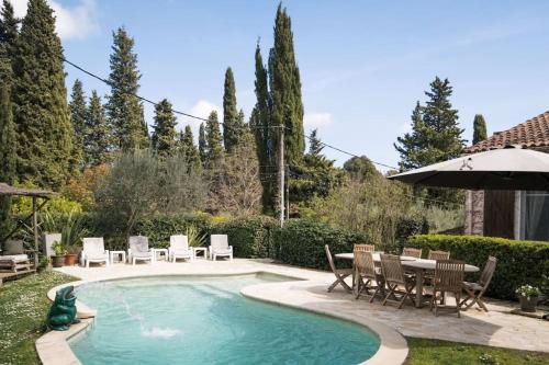 een zwembad met stoelen, een tafel en een parasol bij Villa Lei Lernes walking distance to Valbonne in Valbonne