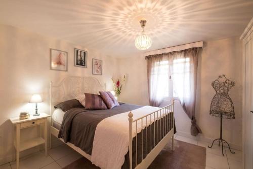 een slaapkamer met een wit bed en een raam bij Villa Lei Lernes walking distance to Valbonne in Valbonne