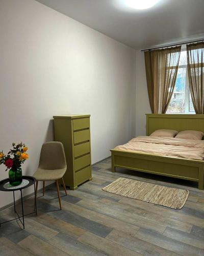 a bedroom with a bed and a chair and a table at ГОТЕЛЬ RIDMAS in Bila Tserkva