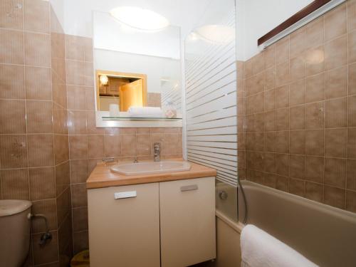 une salle de bain avec un lavabo, un miroir et une baignoire dans l'établissement Studio au pied des pistes avec superbe vue et parking privé - FR-1-343-217, à Chamonix-Mont-Blanc