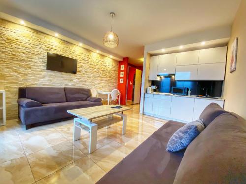 a living room with a couch and a table and a kitchen at Apartamenty Szóstka Wisła Kamienna in Wisła