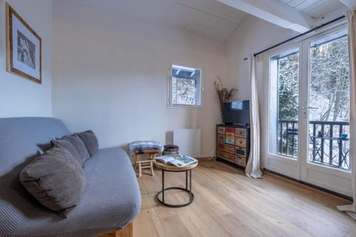 uma sala de estar com um sofá e uma janela em Apt with nice view near the center of Chamonix em Chamonix-Mont-Blanc