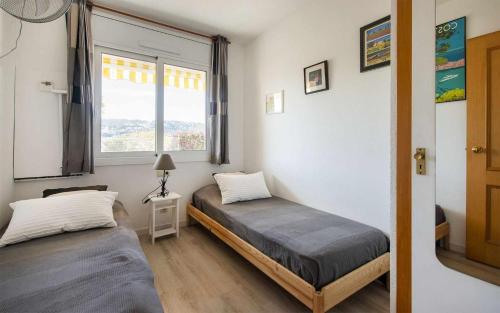 een slaapkamer met twee bedden en een raam bij Apartamento Terrassa 1 - Gran terraza y vistas in Tossa de Mar