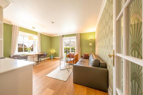 a living room with a couch and a table at Hotel Parkresidenz Christian VIII in Archsum