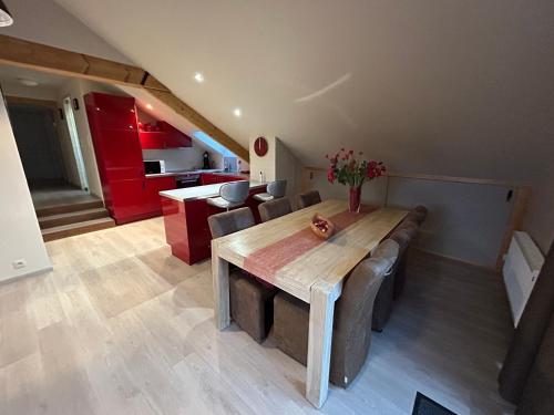 a kitchen and dining room with a wooden table and chairs at Race & Rooms Appartment in Stavelot