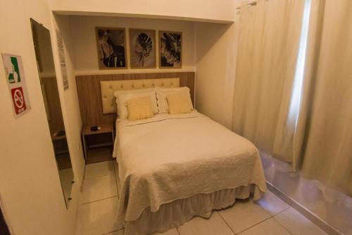 a small bedroom with a bed in a room at Pousada da Leide in Fernando de Noronha