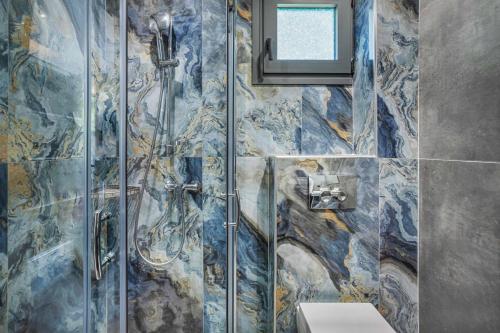 uma casa de banho com uma cabina de duche e um WC. em NewStory Luxury Suites Possidi em Possidi