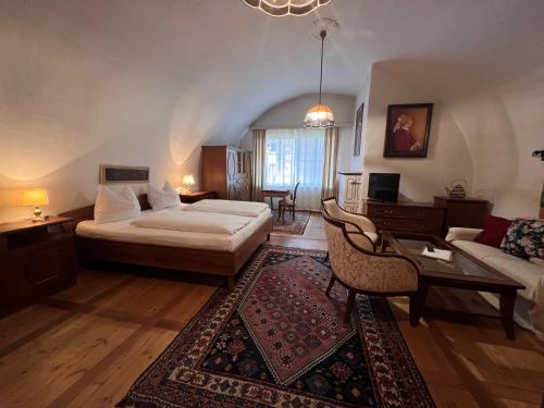 een slaapkamer met een bed en een woonkamer bij Hotel Gasthof Kohlmayr in Gmünd in Kärnten