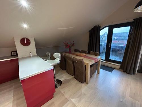 a kitchen with a wooden table and a desk with at Race & Rooms Appartment in Stavelot