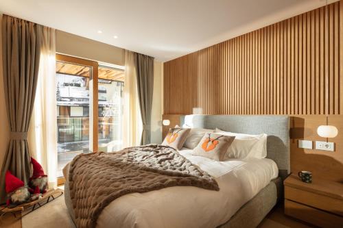 - une chambre avec un grand lit et une fenêtre dans l'établissement Campiglio WOOD, à Madonna di Campiglio