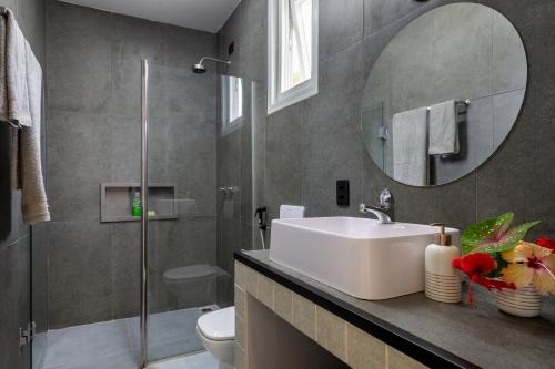 y baño con lavabo y espejo. en Quartos Do Vilarejo, en Trancoso