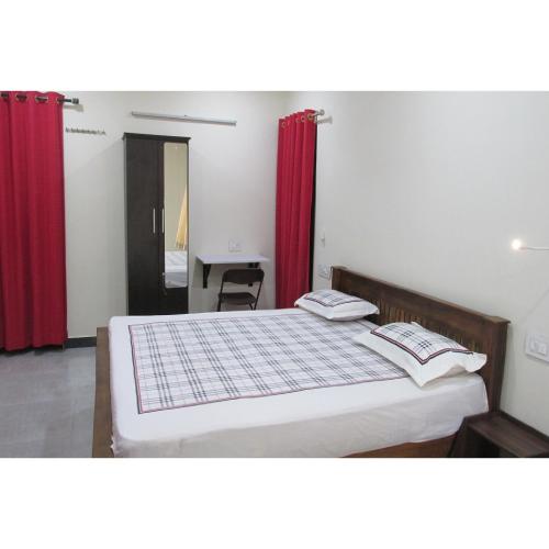 a bedroom with a large bed with red curtains at Nature Villa Kochi in Alwaye