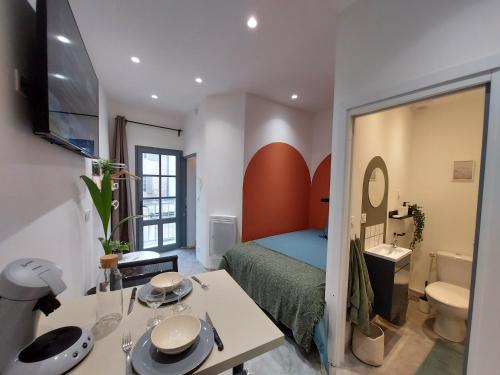 a small bedroom with a bed and a bathroom at Les studios de Théophile - Calme absolu - Wifi - Centre historique in Arles