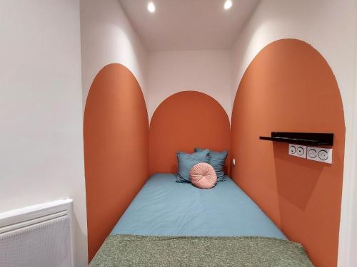 a childs bedroom with an orange and white wall at Les studios de Théophile - Calme absolu - Wifi - Centre historique in Arles