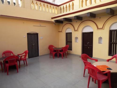a room with red chairs and tables in a building at Foreigners Inn in Varanasi
