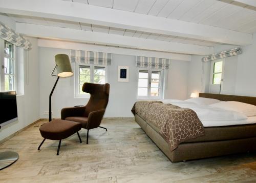 a bedroom with a bed and a chair and a lamp at Ferienhaus Oberstaader Fewo Fisch in Öhningen