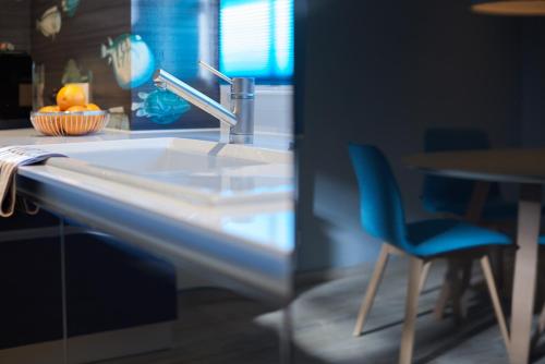 a kitchen with a sink and a blue chair at Ferienhaus Oberstaader Fewo Maisonette in Öhningen