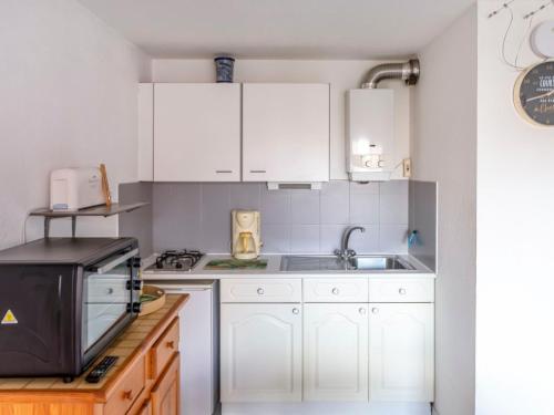 a kitchen with white cabinets and a sink at Apartment Amourêva-1 by Interhome in Cap d'Agde