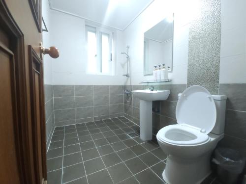 La salle de bains est pourvue de toilettes et d'un lavabo. dans l'établissement OYO Hostel Myeongdong 5, à Séoul