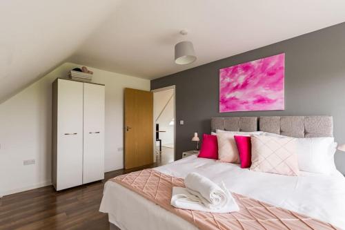 a bedroom with a large white bed with pink pillows at TM - Rana Court 1 Bedroom apartment with balcony in Oxford