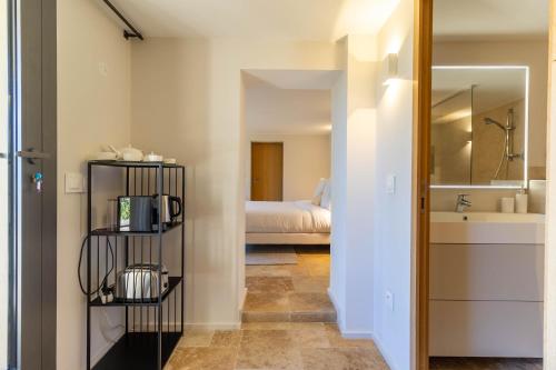 a room with a bathroom with a bed and a mirror at Mougins Collection - Magnifique Maison du Vieux Village de Mougins, avec Bassin à débordement et vues Mer et Montagnes in Mougins