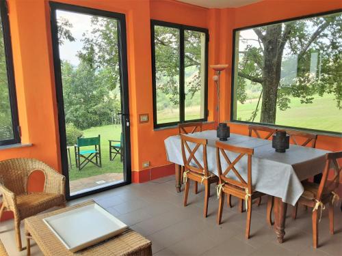 a dining room with orange walls and a table and chairs at Holiday Home Busani by Interhome in Castello di Contignaco
