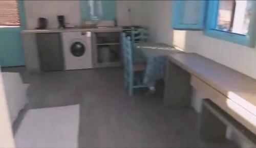 a kitchen with a washing machine in a room at PARADISE ON THE KANTOUNI BEACH in Panormos Kalymnos