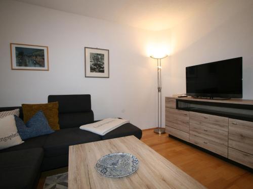 ein Wohnzimmer mit einem Sofa und einem Flachbild-TV in der Unterkunft Apartment Neurauter - FGZ158 by Interhome in Fügen