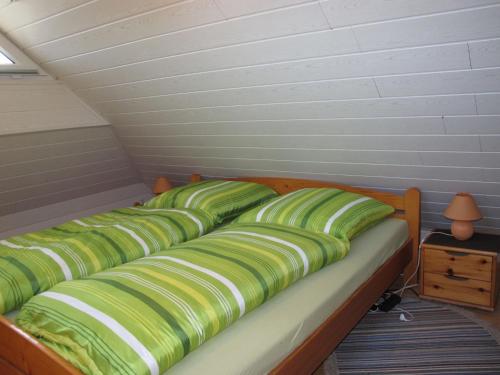 ノルデンにあるApartment Claudia by Interhomeの緑の枕が備わるドミトリールームのベッド1台分です。