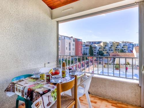 a table and chairs on a balcony with a view of a city at Apartment Port Richelieu 4-2 by Interhome in Cap d'Agde