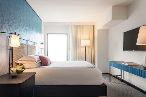 a bedroom with a large white bed and a window at Kimpton Hotel Fontenot by IHG in New Orleans