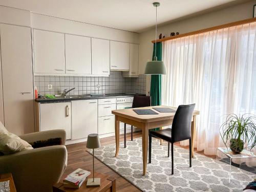 uma cozinha com uma mesa e uma sala de jantar em Apartment Deli by Interhome em Alvaneu