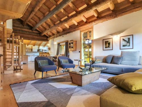 - un salon avec un canapé, des chaises et une table dans l'établissement Apartment Chalet Baita Tabià Dolomites by Interhome, à Bellamonte