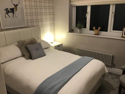 een slaapkamer met een groot wit bed en een raam bij Redstone Rise Luxury house sleeps 7 in Birkenhead