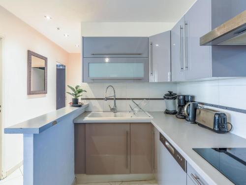 een keuken met witte kasten en een wastafel bij Apartment Héraclès by Interhome in Nice