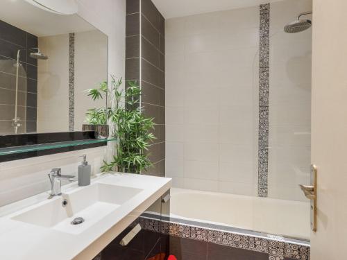une salle de bain avec un lavabo blanc et une baignoire dans l'établissement Apartment Héraclès by Interhome, à Nice