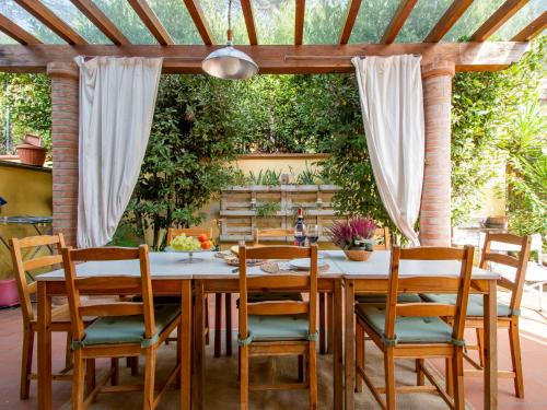 un tavolo da pranzo con sedie e un soffitto di Holiday Home La Rondine by Interhome a Pugnano