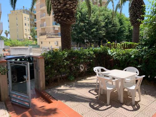 a table and chairs sitting on a patio with palm trees at Apartment Troiani by Interhome in Porto dʼAscoli