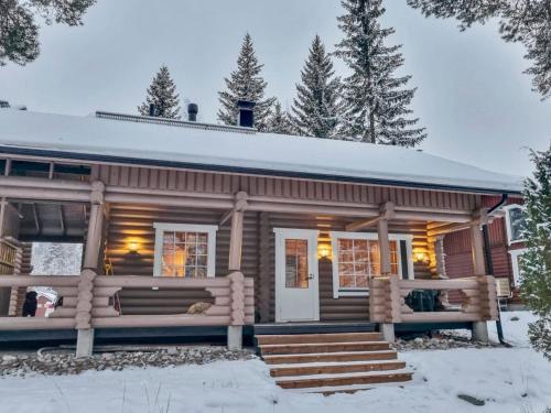 ein Blockhaus mit einer Veranda im Schnee in der Unterkunft Holiday Home Tahkon tikka by Interhome in Tahkovuori