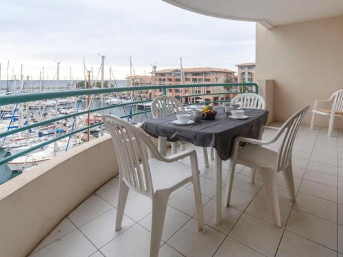 una mesa en un balcón con vistas al puerto en Apartment L'Open-2 by Interhome, en Fréjus