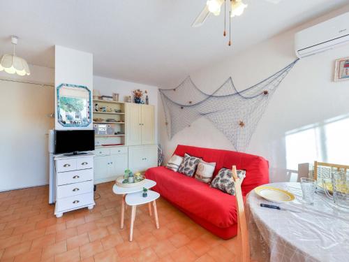 un salon avec un canapé rouge et une télévision dans l'établissement Apartment Le Lagon Bleu-3 by Interhome, au Cap d'Agde
