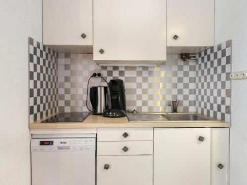 une cuisine avec des armoires blanches et un évier dans l'établissement Apartment Le Lagon Bleu-3 by Interhome, au Cap d'Agde