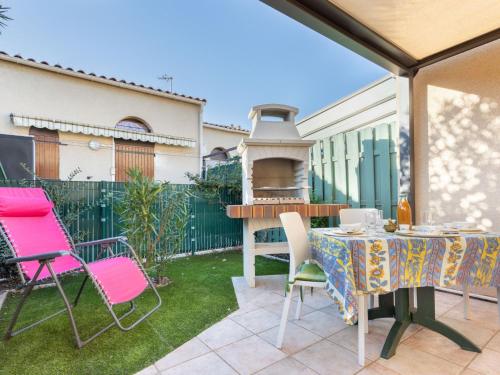 un patio avec une table, des chaises et un barbecue dans l'établissement Holiday Home Le Hameau du Port by Interhome, à Saint Cyprien Plage
