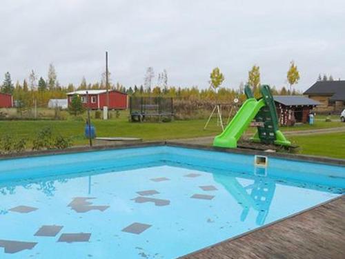 una piscina con scivolo e un parco giochi di Holiday Home Uisku by Interhome a Punkalaidun