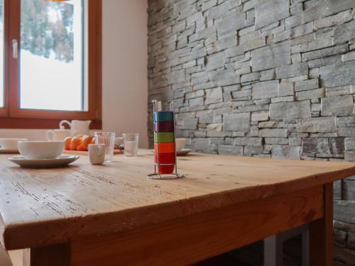 - une table en bois avec une bougie multicolore dans l'établissement Apartment Rosablanche E003A by Interhome, à Siviez